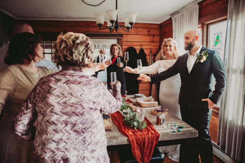 A family sharing a toast with a bride and groom at their intimate wedding in Maine.