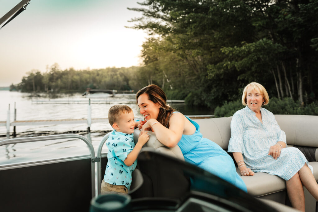 A mother and child on a boat at a family camp in Raymond, Maine and a grandmother looking on