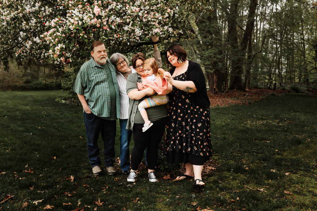 A queer family under cherry blossoms at Gilsland Farm in Falmouth, Maine 