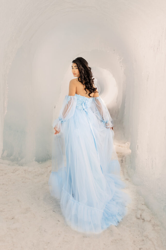 A girl walking through a tunnel at the New Hampshire Ice Castles