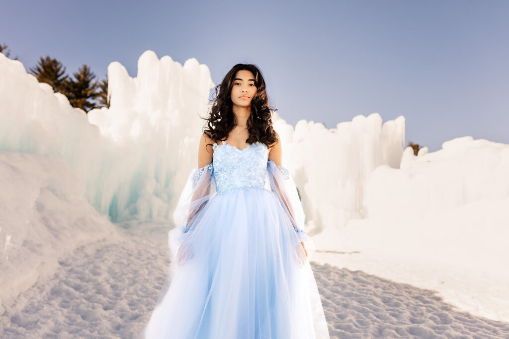 A girl in a blue tulle dress in front of the New Hampshire Ice Castles