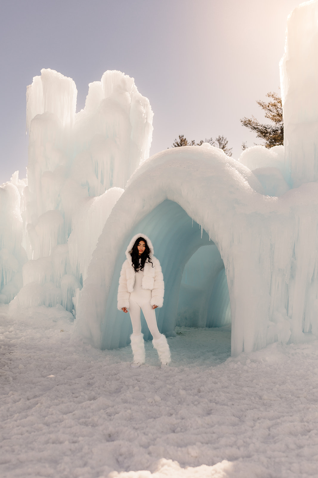 A girl standing in front of the New Hampshire Ice castles for her magical, creative, Quinceañera session