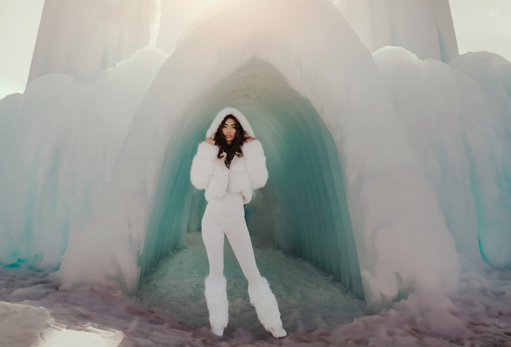 A girl stands in an entrance to one of the New Hampshire Ice Castles