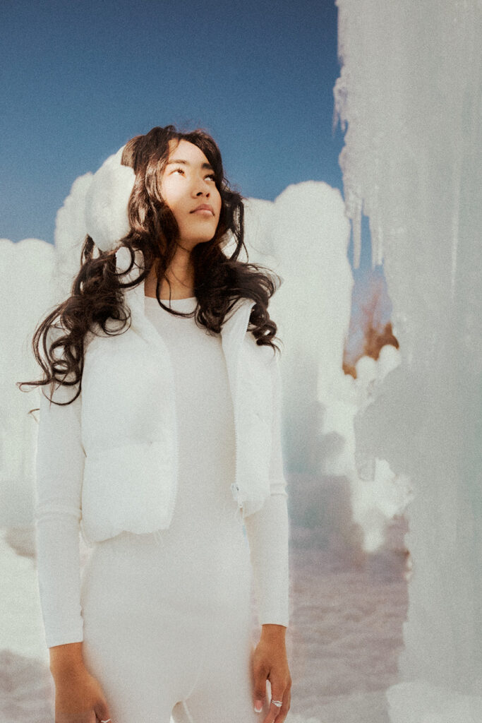 A girl looks to the light by an ice wall at the New Hampshire Ice Castles