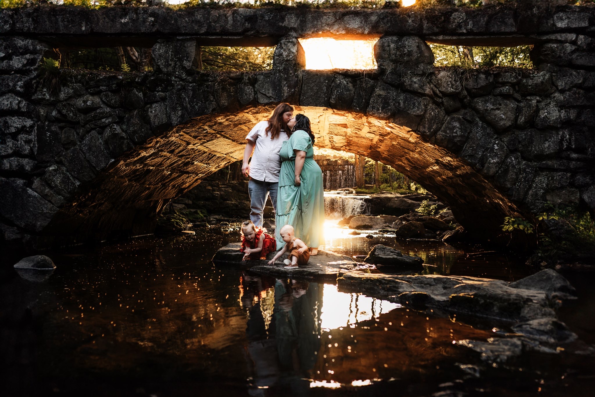 A family poses in front of the hobbit bridge in Hallowell Maine