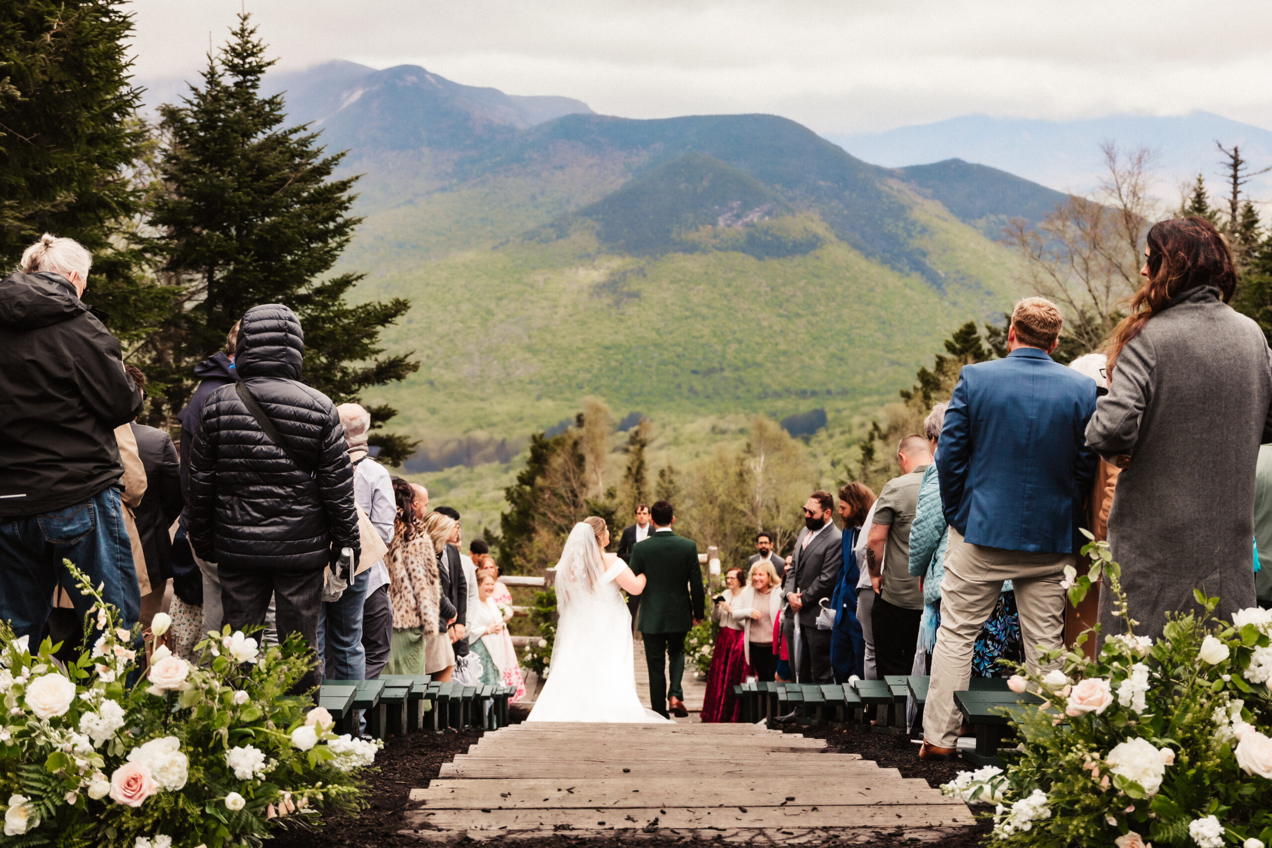 A bride walks down the aisle against a mountain backdrop at Loon Mountain
