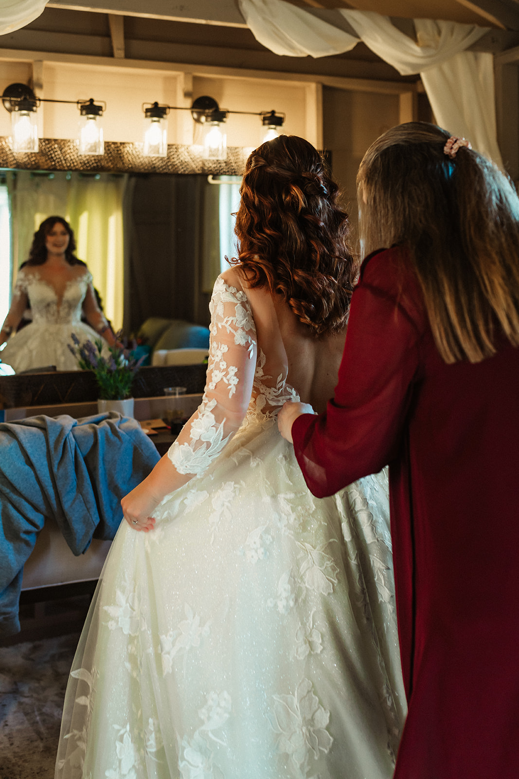 A mother buttons her daughters wedding gown