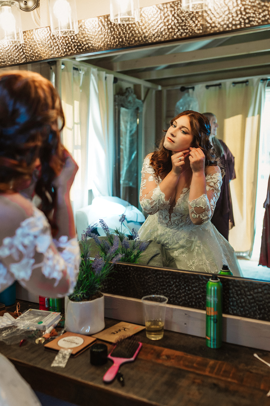 A bride gets her earrings on in preparation for her wedding at Harvest Moon