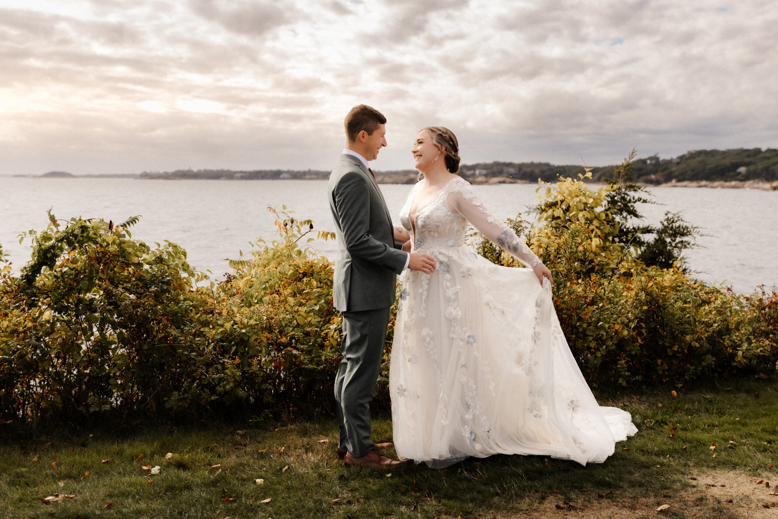 A couple in front of a seaside backdrop in Gloucester, MA
