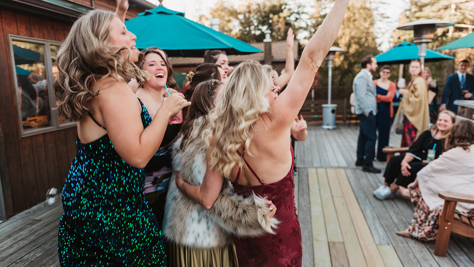 Friends cheer whild taking a photo during a wedding reception