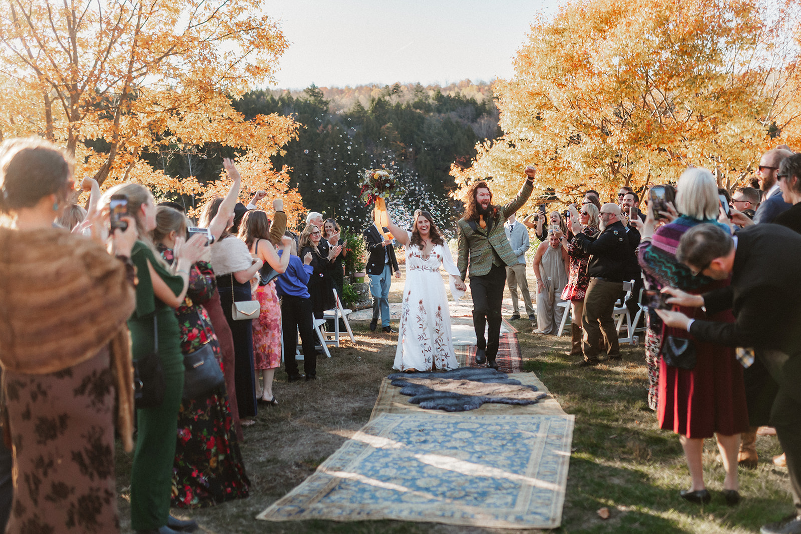 A couple exits their ceremony surrounded by loved ones and bubbles